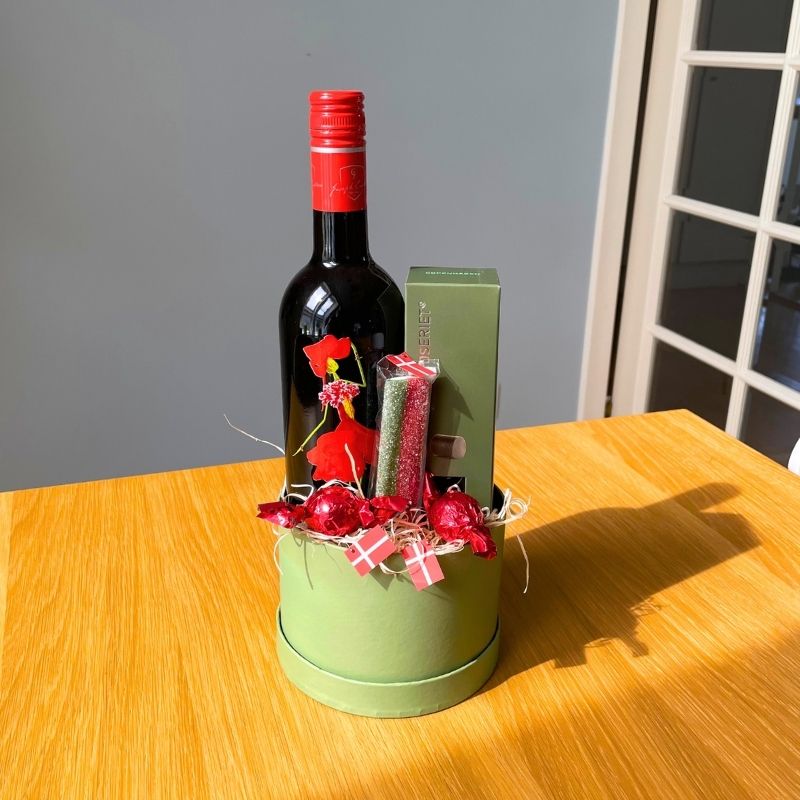 Gave i grøn hatteæske med rødvin, chokolade og andre søde sager