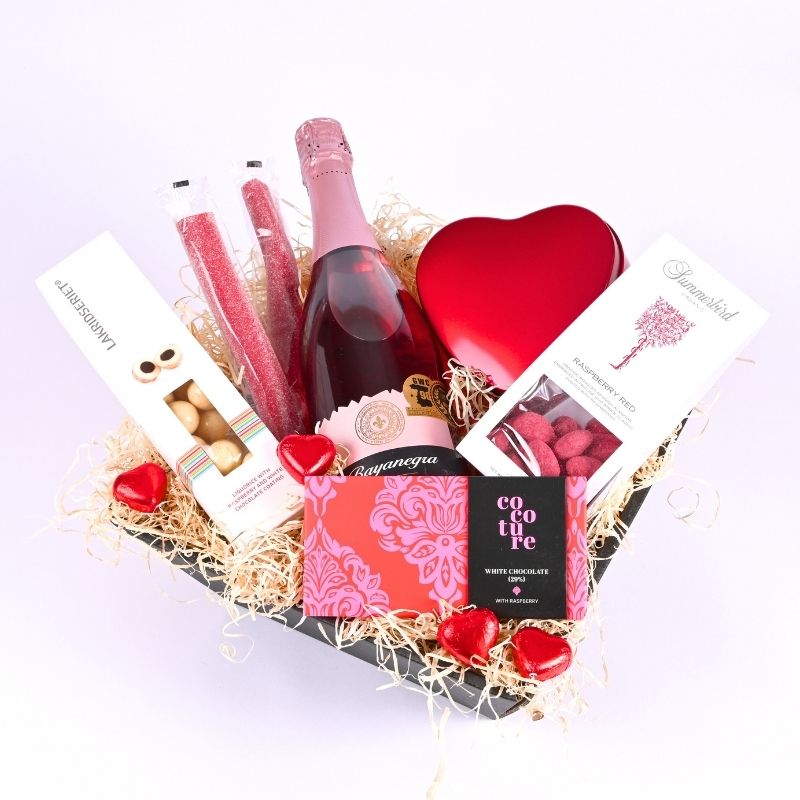 Gavekasse med forskellige vin og chokolade, alt sammen i lyserøde farver