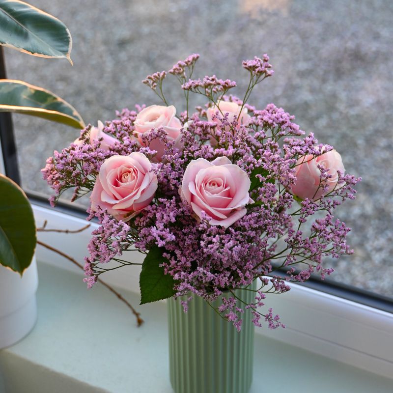 Buket med lyserøde roser og limonium