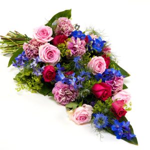 Bårebuket af årstidens blomster i pink, blå, lilla og lyserød.