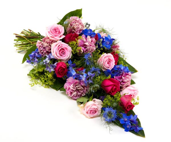Bårebuket af årstidens blomster i pink, blå, lilla og lyserød.