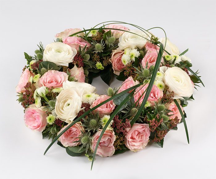 Rundpyntet krans i lyse farver - Blomster til begravelse