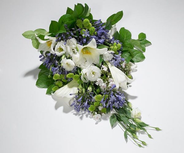 Bårebuket af årstidens blomster i hvid og blå.