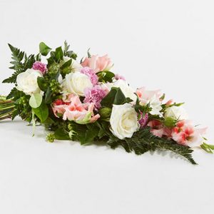 Bårebuket af årstidens blomster i hvid og lyserød.