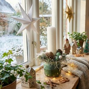 Julepyntet vindueskarm, hvor der står en kalenderlys-dekoration i hvid og mint.