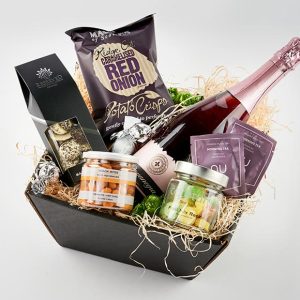 Gavekurv med bobler, chips, og andet gourmet snacks.