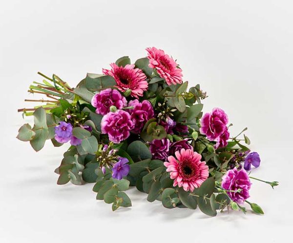 Bårebuket med blomster i pink og lilla.