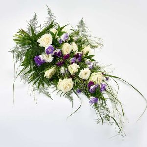 Bårebuket med hvide og blå blomster.