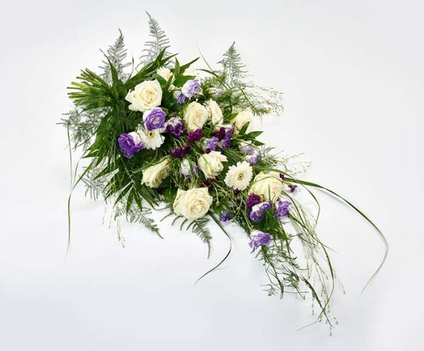 Bårebuket med hvide og blå blomster.