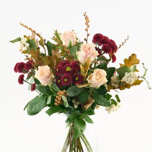 Luftig buket i gyldne og lyse nuancer af bl.a. roser, monbretia, santini chrysanthemum og efterårsløv.