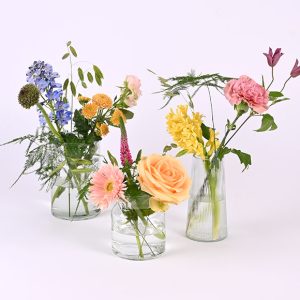 Glasvaser med blomster som bordpynt