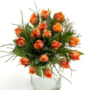 Buket orange tulipaner i en gennemsigtig glasvase.