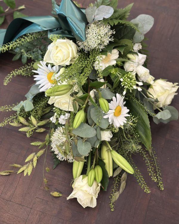 En bårebuket bundet af hvide blomster