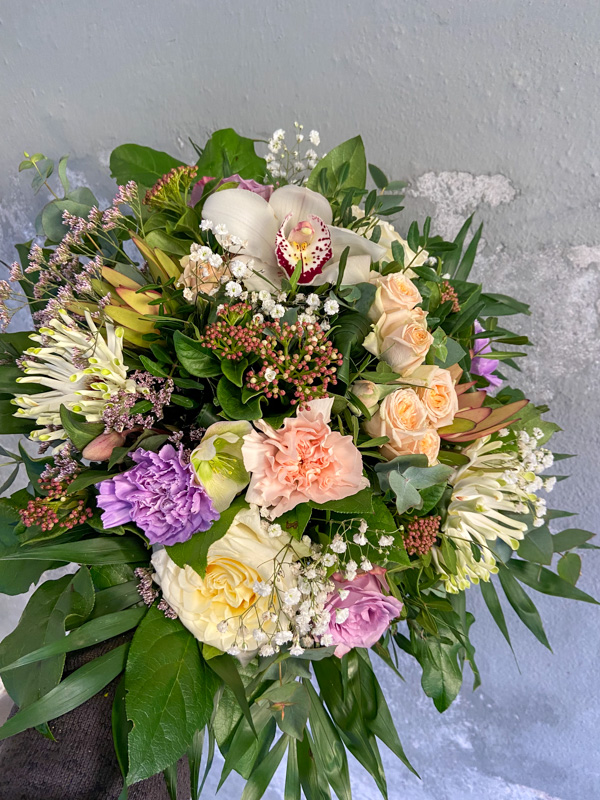 En lav tæt buket i lyse farver.