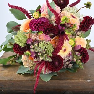 Brudebuket af georginer og riser i fersken og bordeaux farver.