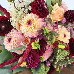 Brudebuket af georginer og riser i fersken og bordeaux farver.