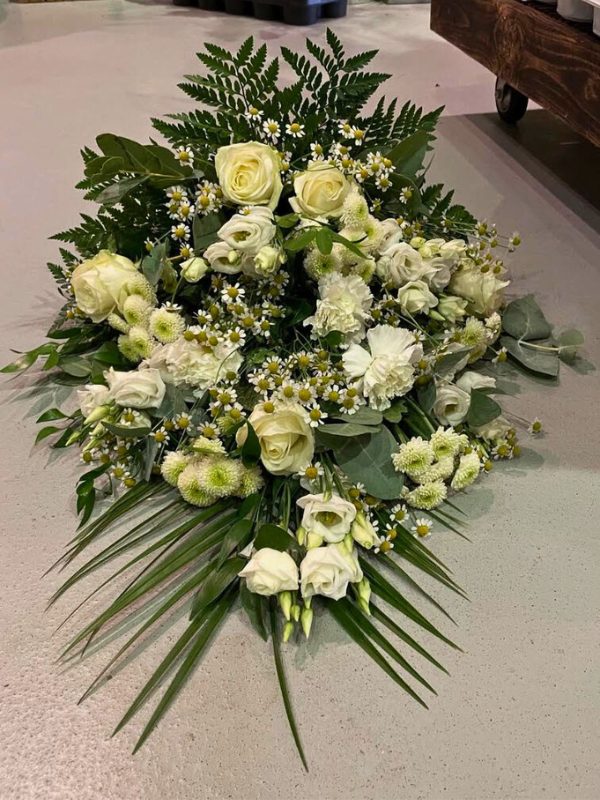 Bårebuket af hvide blomster.