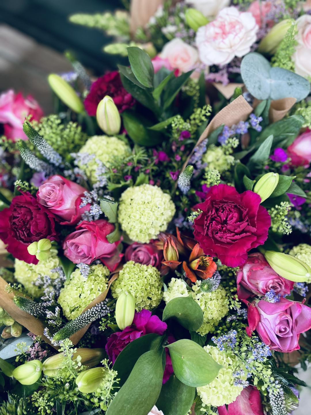 Close-up af en buket i rød, pink, hvid og grøn.