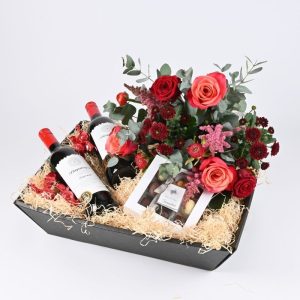 Gavekurv med rødvin, chokolade og en smuk rød buket