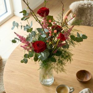 Rød nordisk signaturbuket står på et bord.