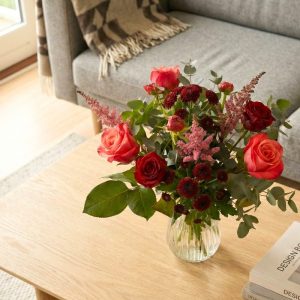 Rød buket står på et sofabord.