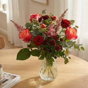 Rød buket står på et spisebord.