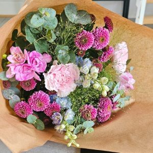 En indpakket buket i lyserød og lyseblå.