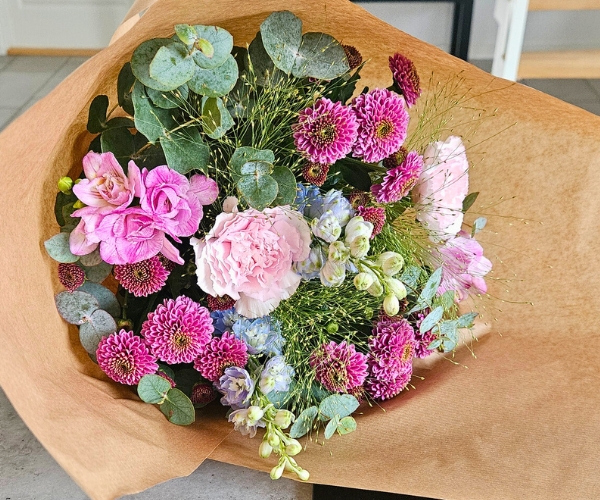 En indpakket buket i lyserød og lyseblå.