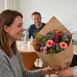 Kvinde får overrakt en smuk buket.