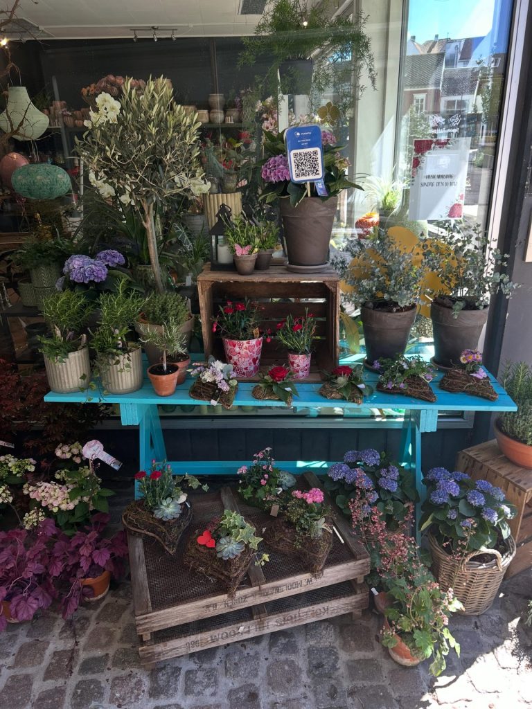 EN blomsterbutiks facade med en masse flotte udendørsplanter.