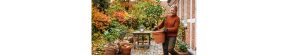Kvinde flytter planter fra terrassen.