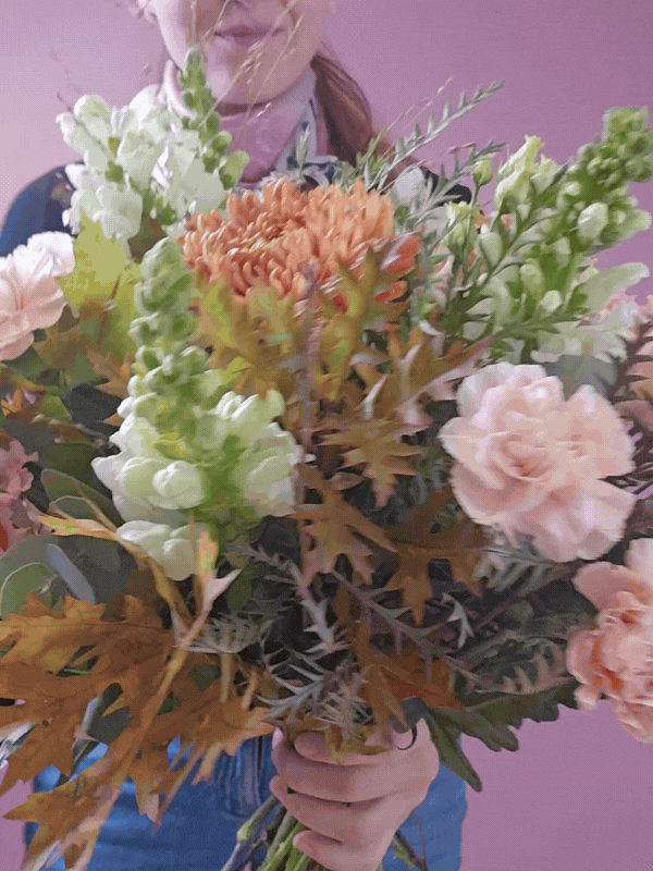 Buket vises frem af blomsterdekoratør.