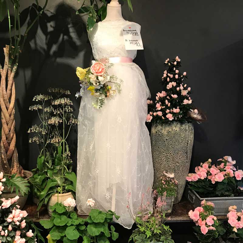 Brudekjole med blomster i krukker omkring