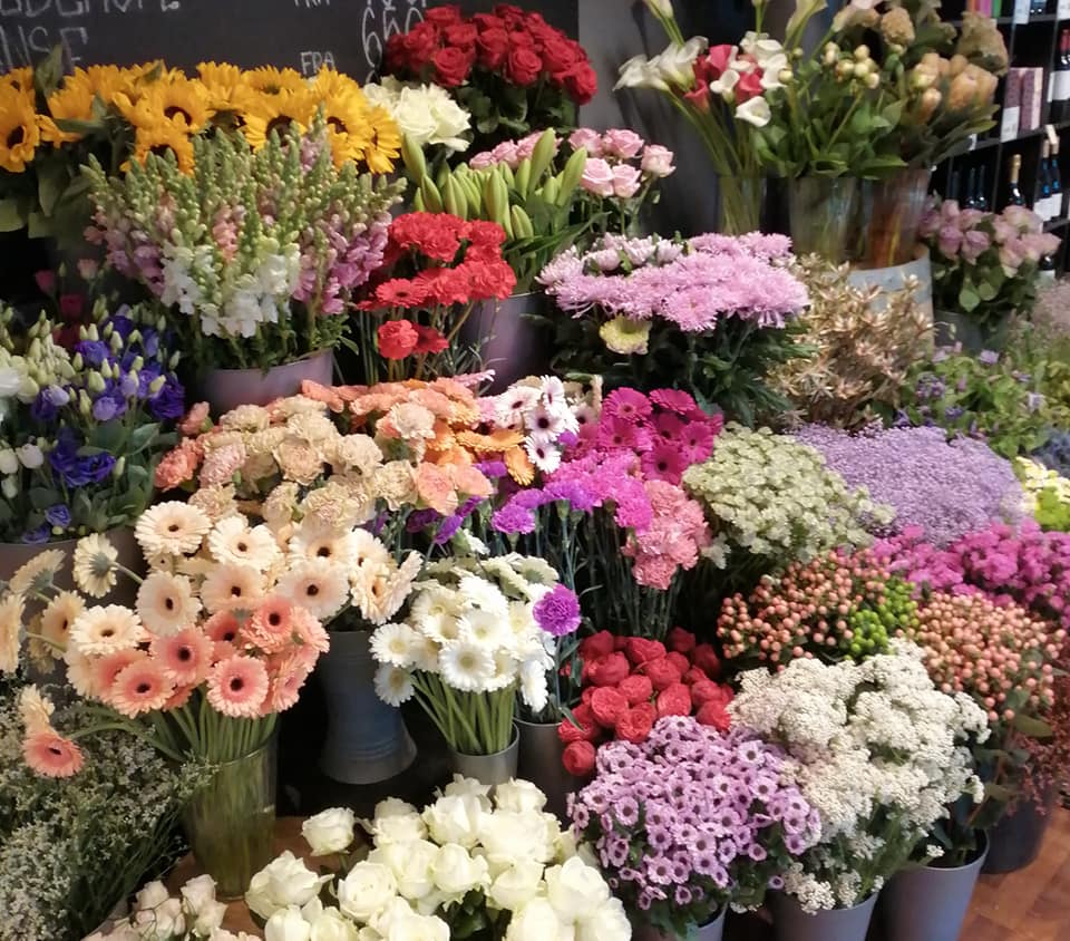 En masse smukke blomster i vaser.
