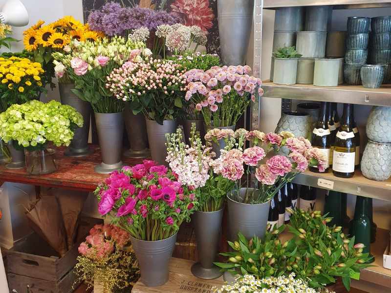 Et udsnit af afskårne blomster i vaser i butikken.